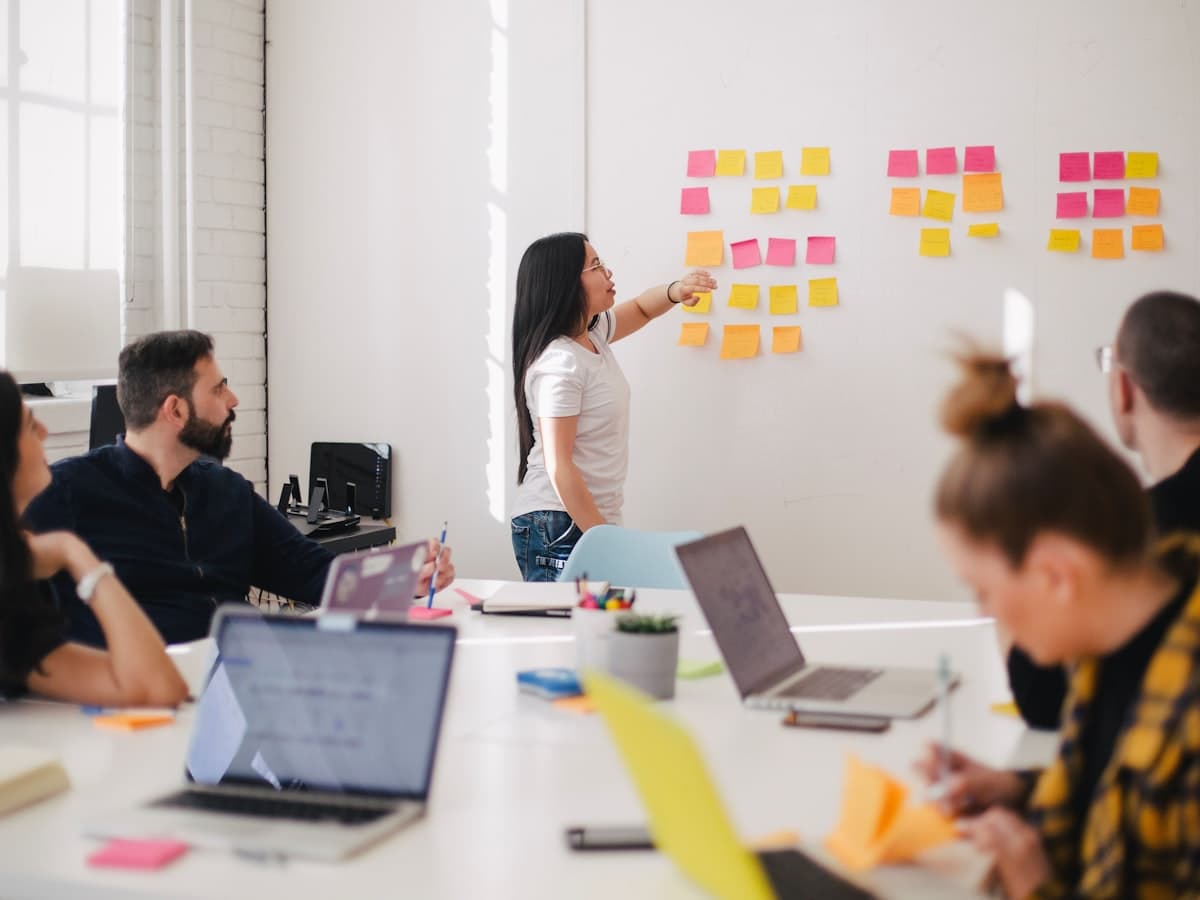 MVP Development — team collaborating with sticky notes and laptops in an agile planning session